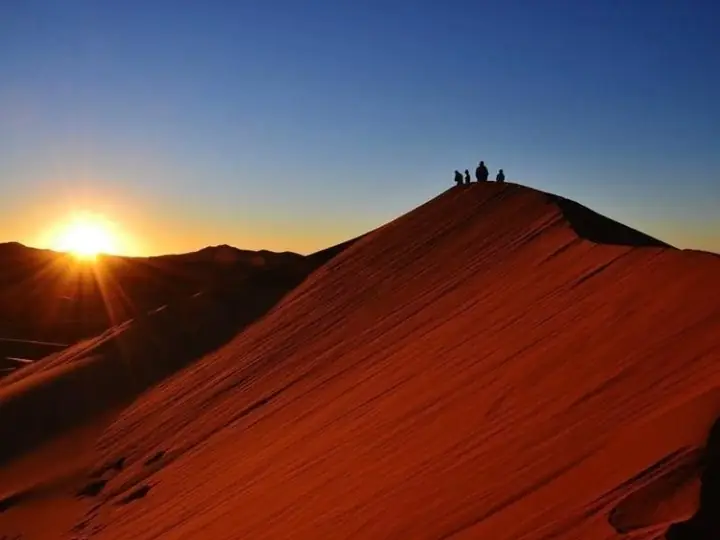 Sol sobre la cresta de una gran duna roja en Erg Chebbi