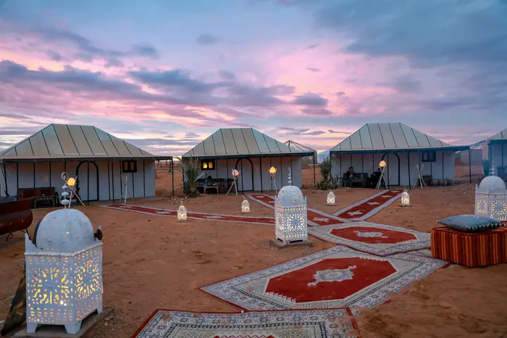 Jaimas de un campamento de lujo en Merzouga al atardecer