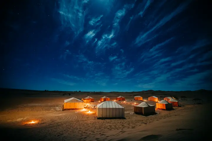 Campamento iluminado bajo el cielo nocturno del Sahara