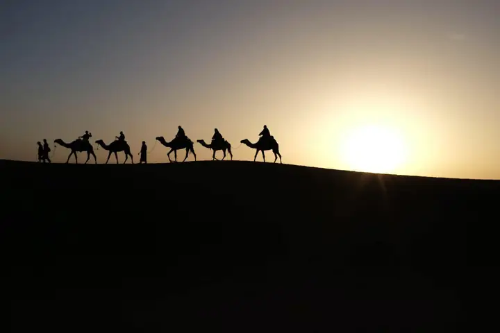 Silueta de una caravana al amanecer en el desierto
